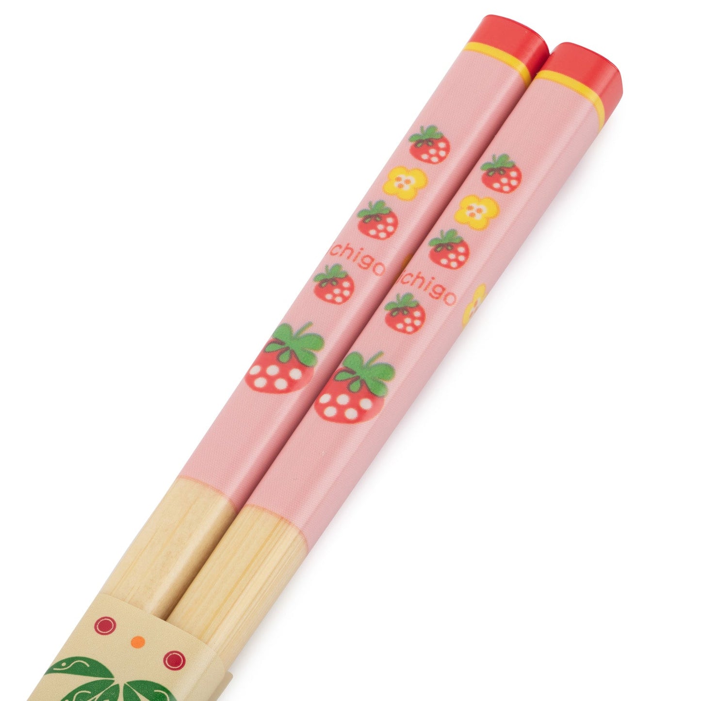 Close-up of children’s chopsticks with pink handles featuring strawberry and flower designs.